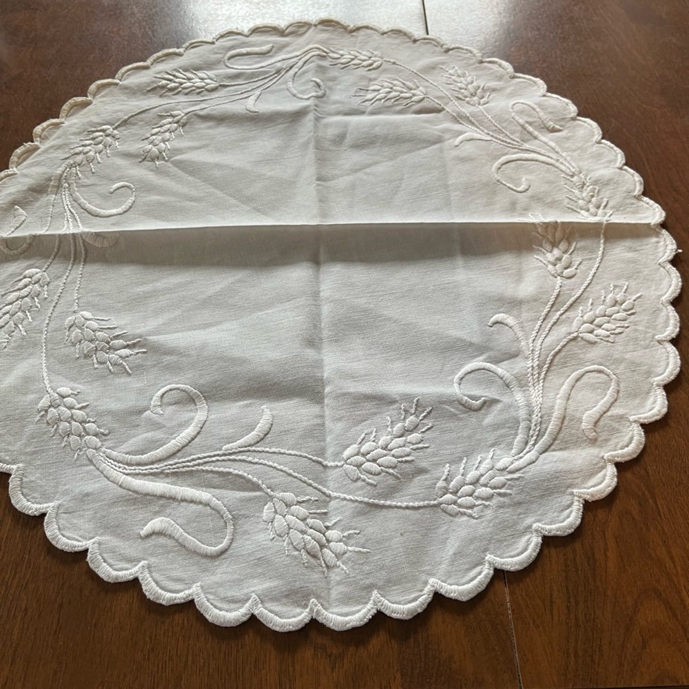 Vintage white embroidered linen doily with scalloped edge wheat pattern.
